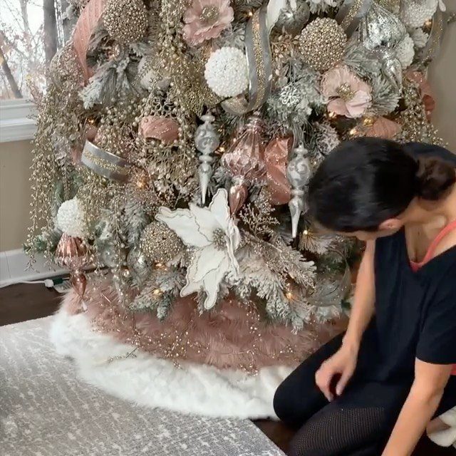 White faux fur tree skirt surrounding the base of a decorated flocked Christmas tree.