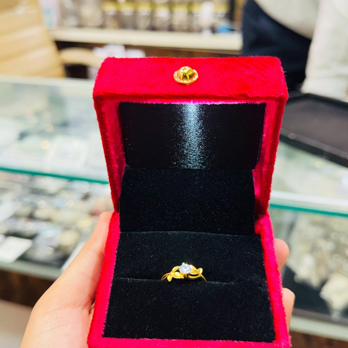 Gold ring with a gemstone in a red velvet jewelry box