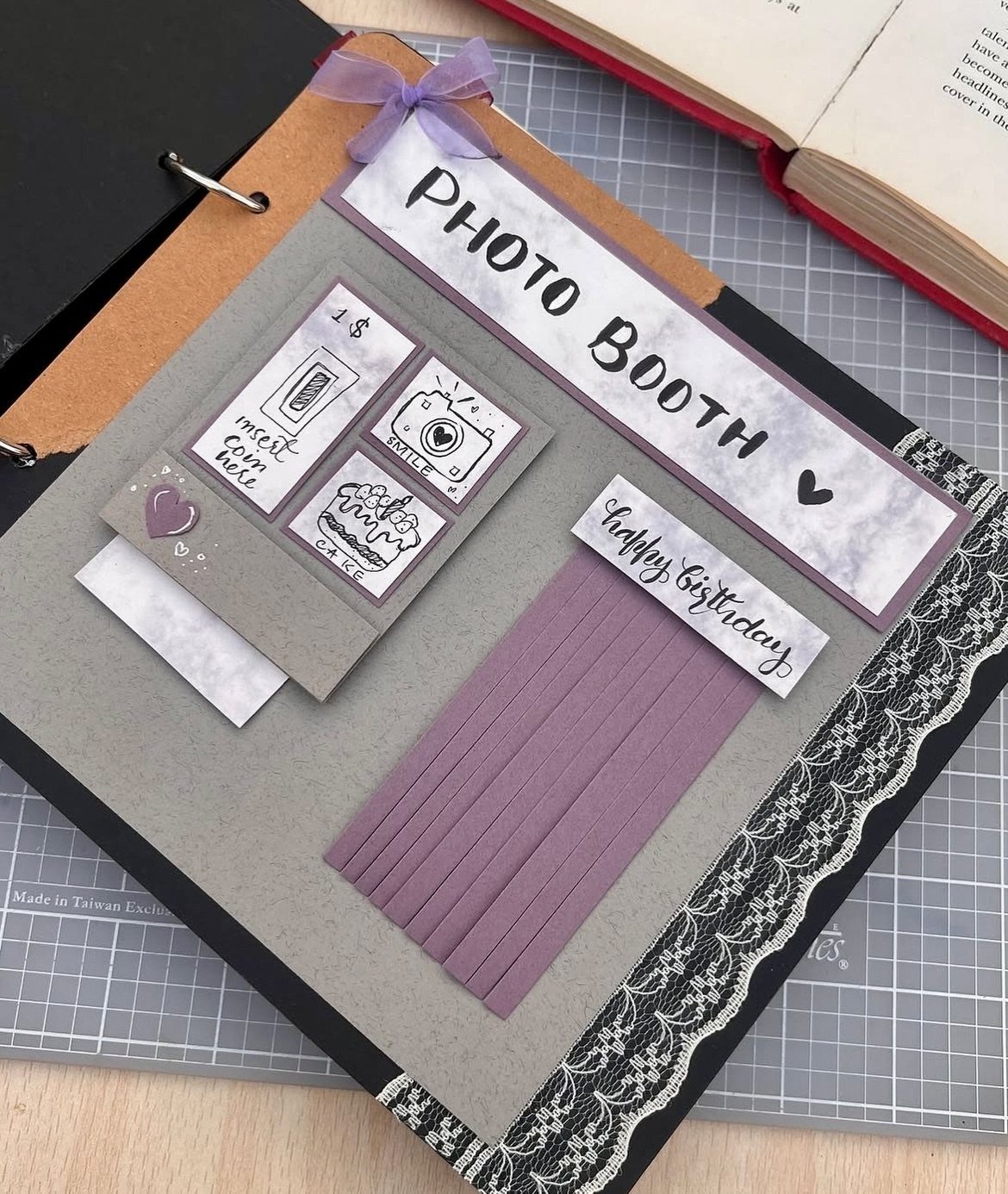 Handmade birthday scrapbook page with photo booth theme and purple accents in a binder