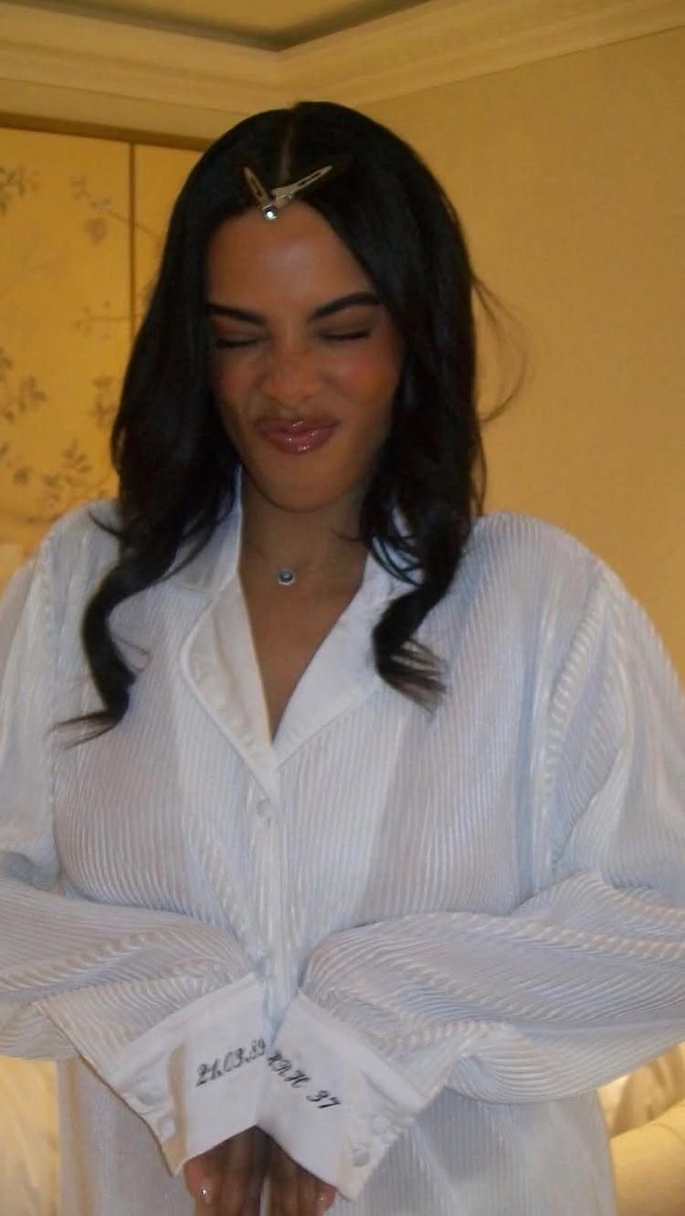 Woman wearing a white button-down shirt with personalized embroidery on the sleeve cuff.