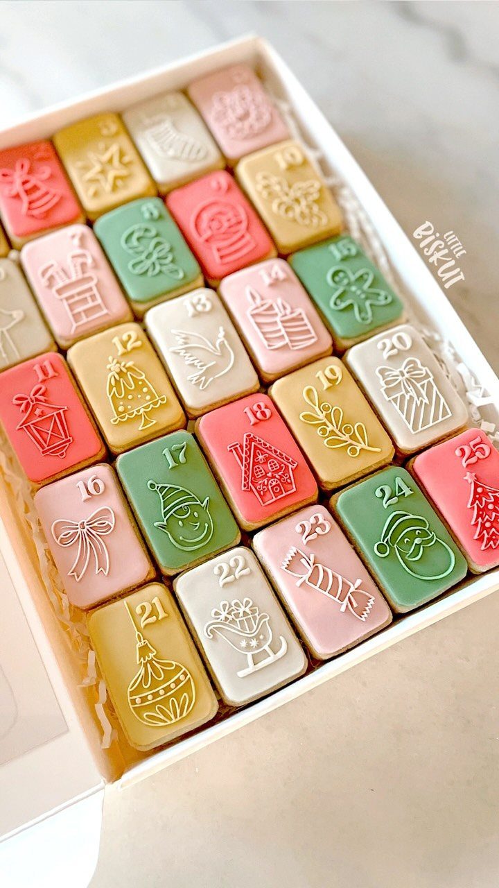 Christmas advent calendar cookies with colorful icing and embossed holiday designs in a box