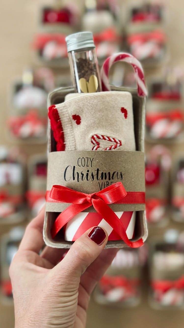Christmas gift box with socks, candy cane, and bottle tied with red ribbon