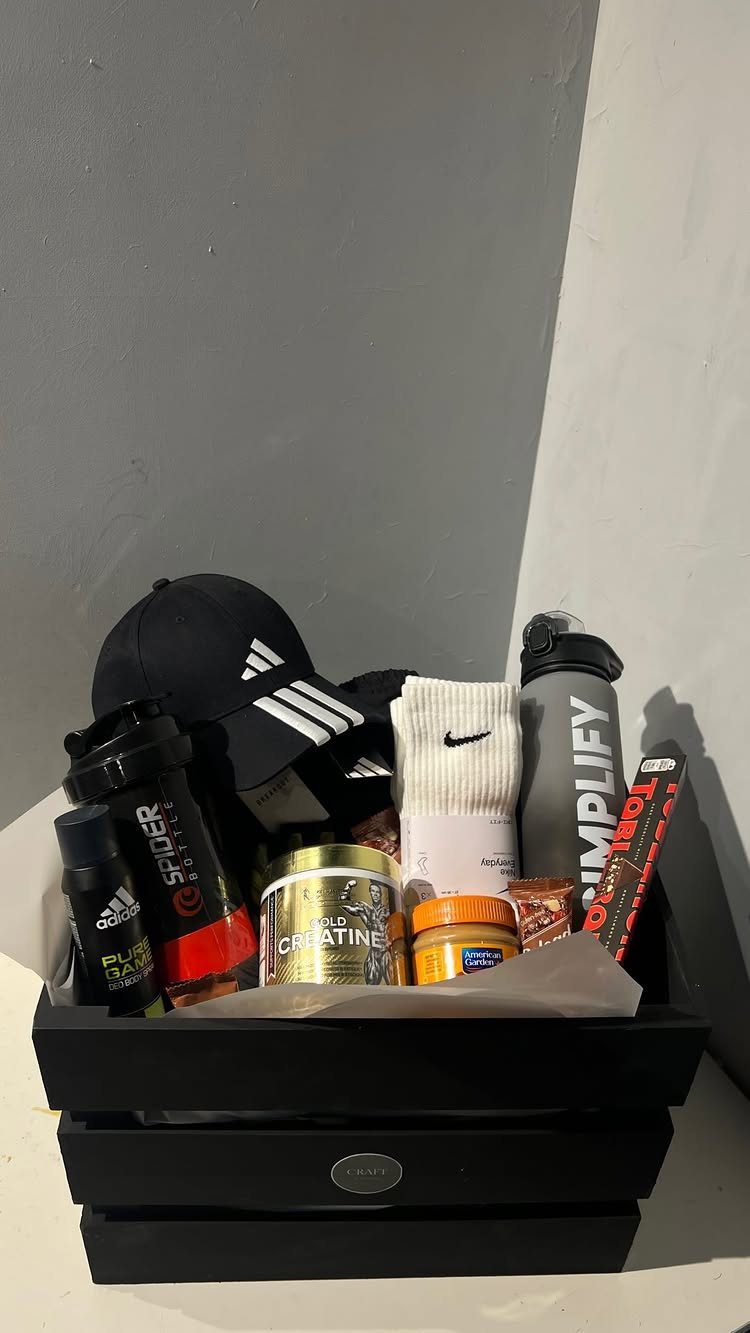 Fitness gift basket with Adidas cap, Nike socks, water bottle, and supplements.