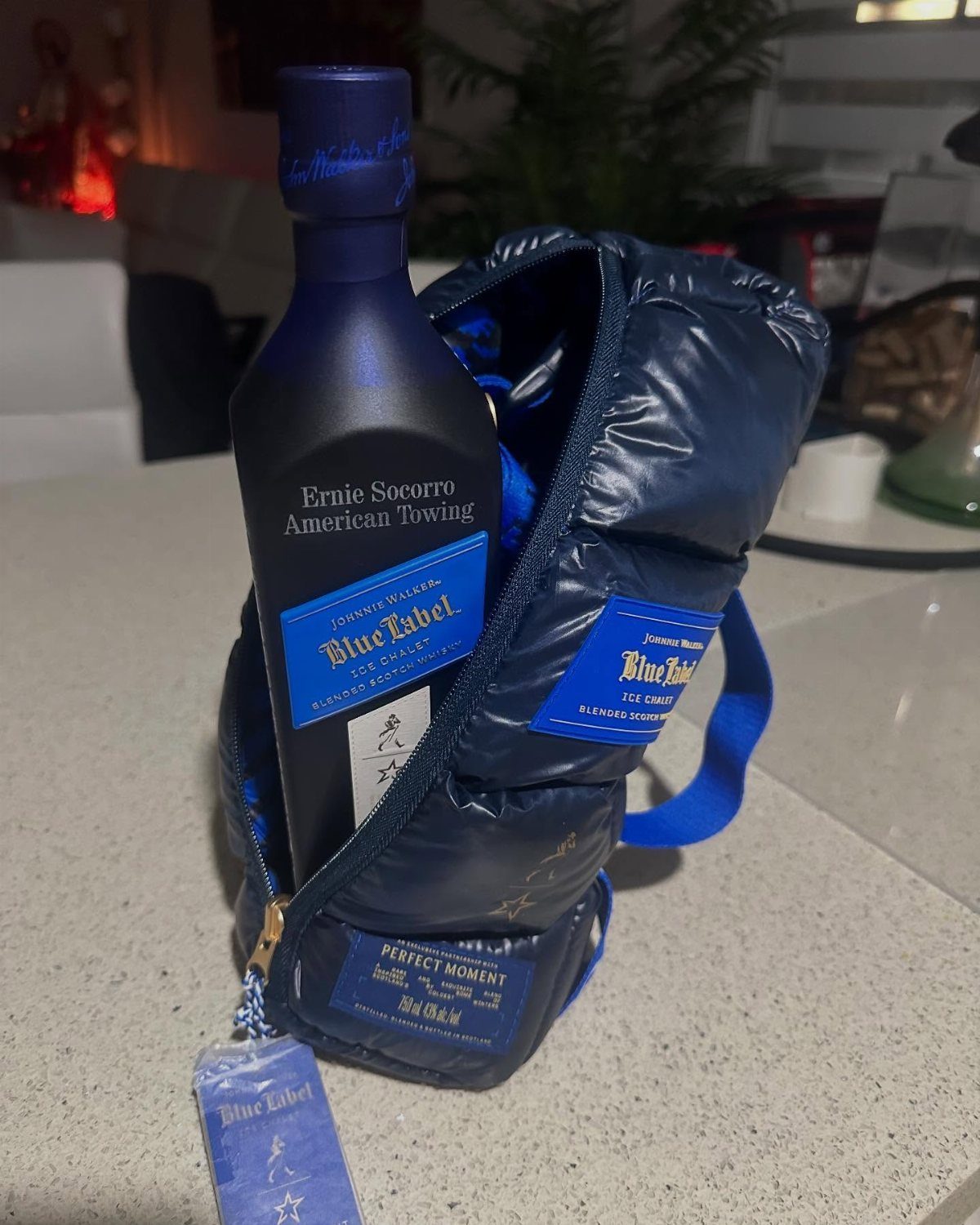 Johnnie Walker Blue Label whisky bottle inside a navy blue puffer jacket cooler.